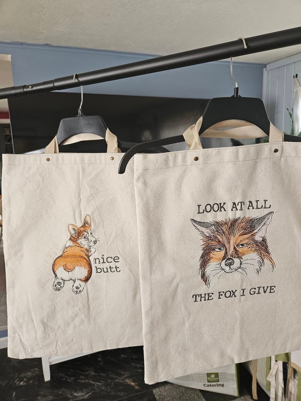 Embroidered canvas tote bags with a corgi design and a fox design