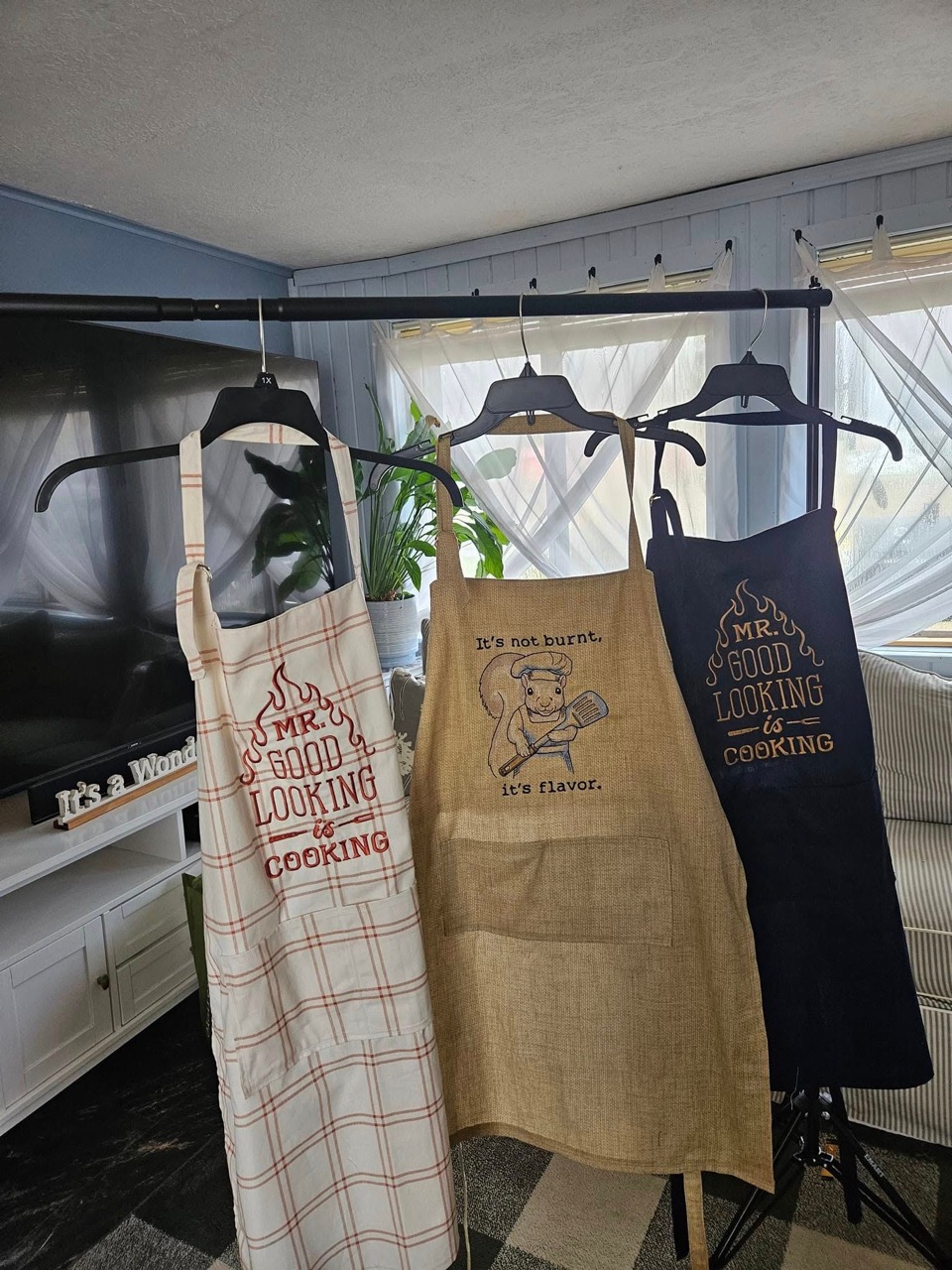 Three embroidered aprons including a "Mr. Good Looking is Cooking" design