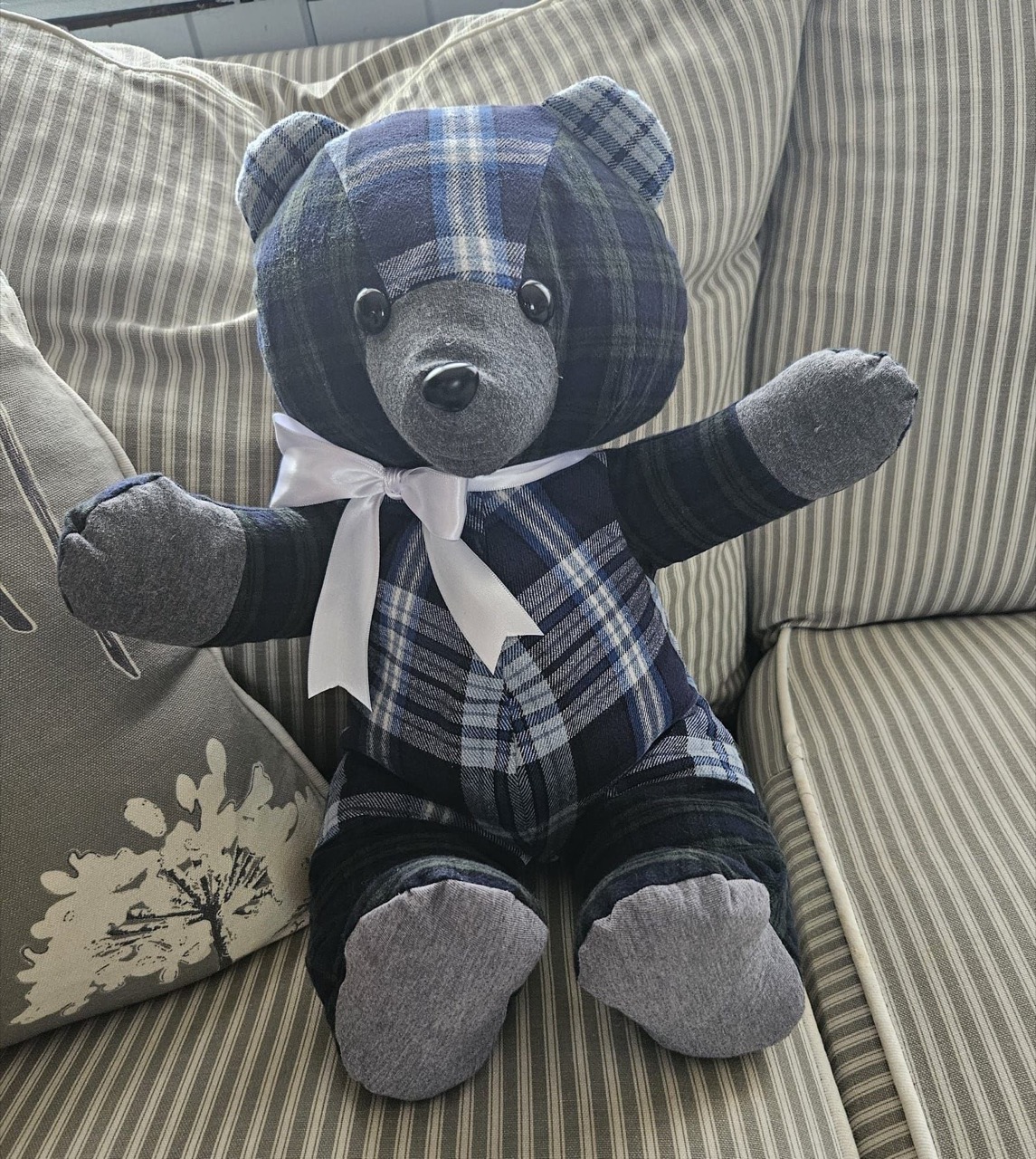 Memory keepsake bear sewn from blue plaid flannel with a white satin bow