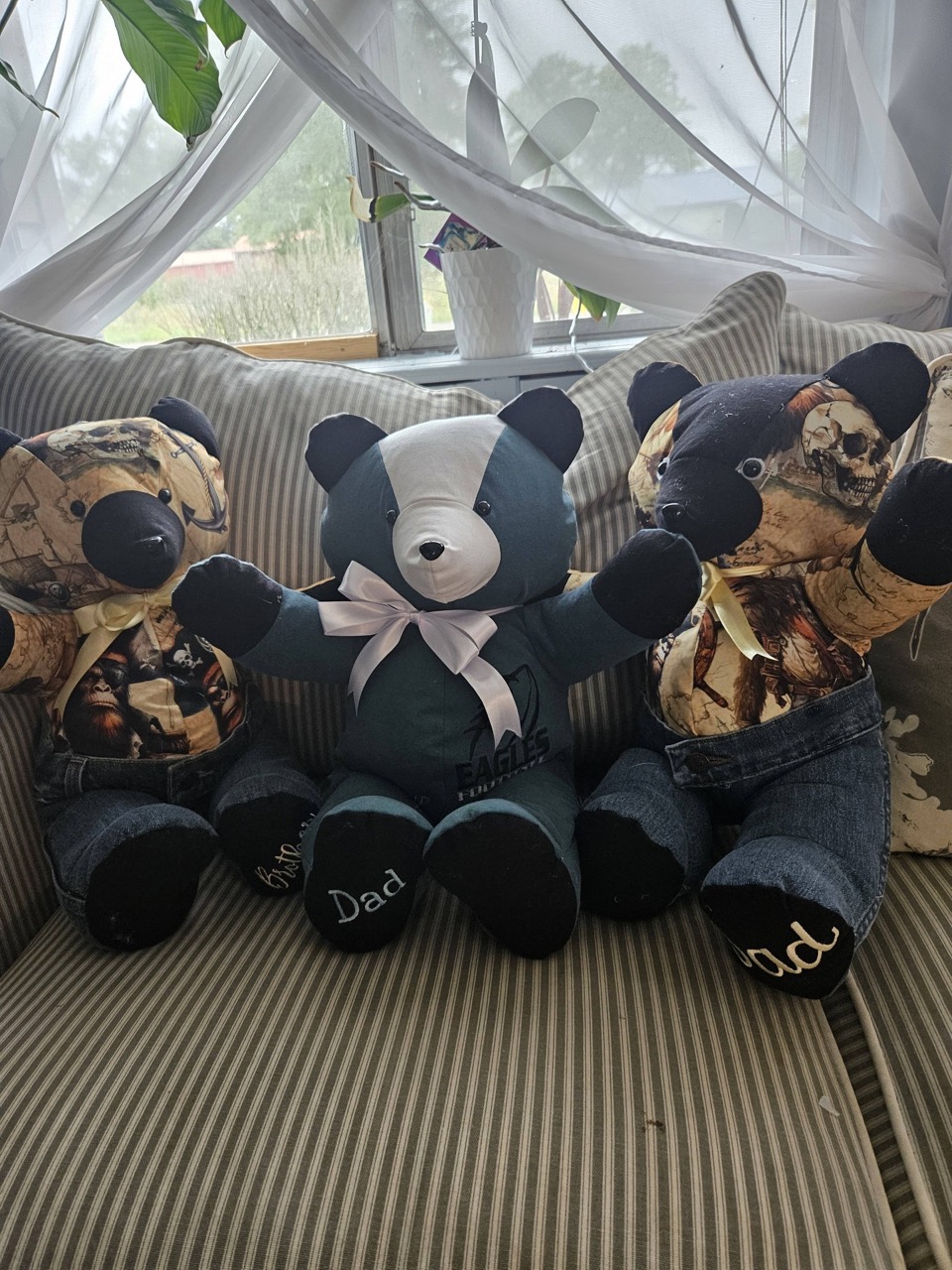 Three memory keepsake bears sewn from camo and denim clothing, each embroidered with Dad on the feet