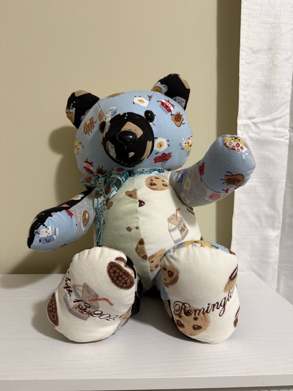 Memory keepsake bear sewn from cookies-and-milk print flannel with a name embroidered on the foot