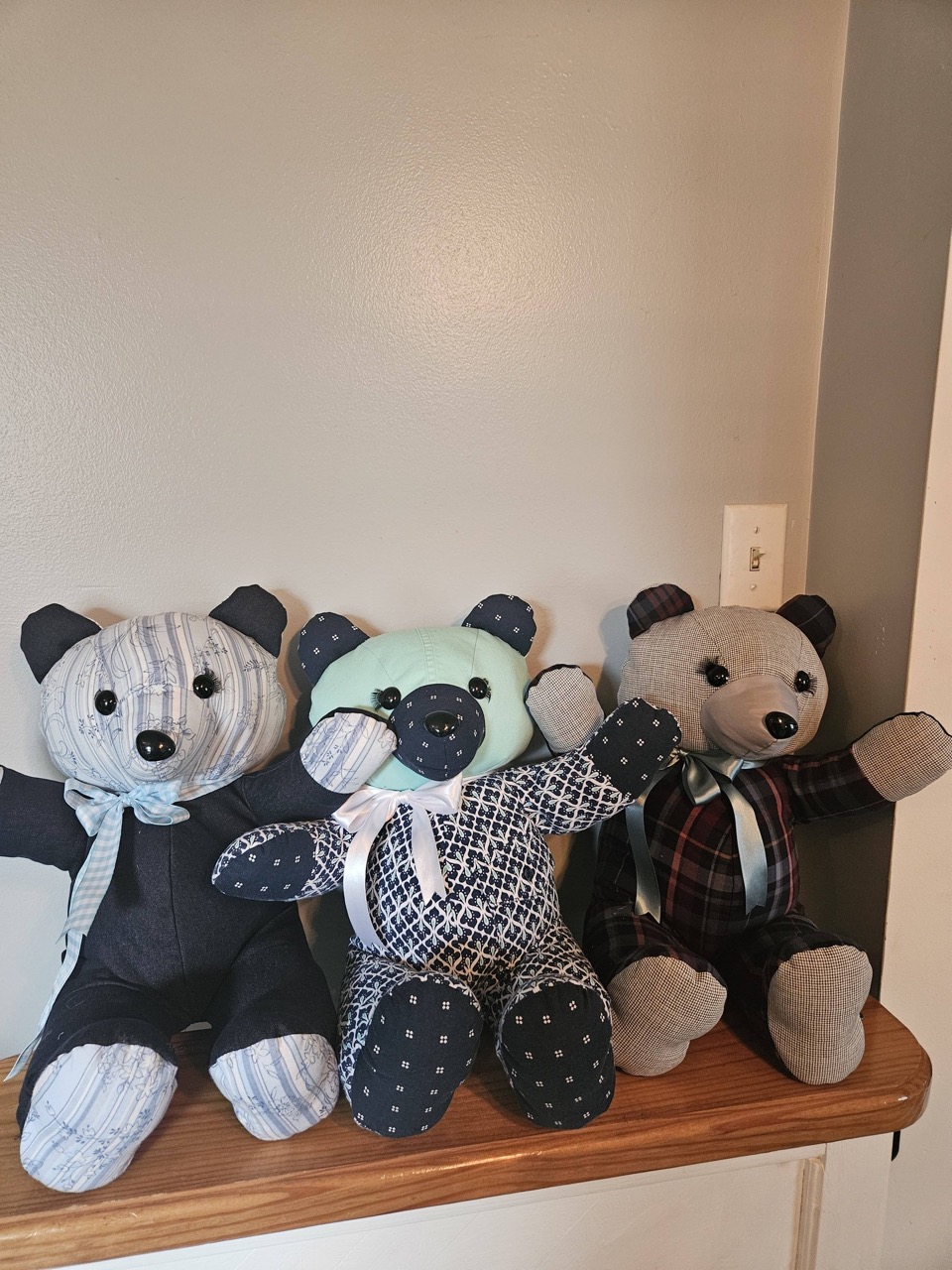 Three memory keepsake bears sewn from button-up dress shirts in blue, navy, and plaid